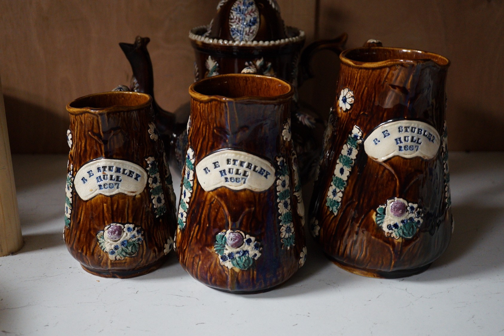A Victorian Measham pottery bargeware teapot and three graduated jugs (4)